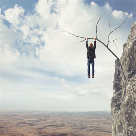 man hanging on a cliff